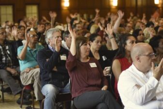 Staff members attending a presentation and raising their hands